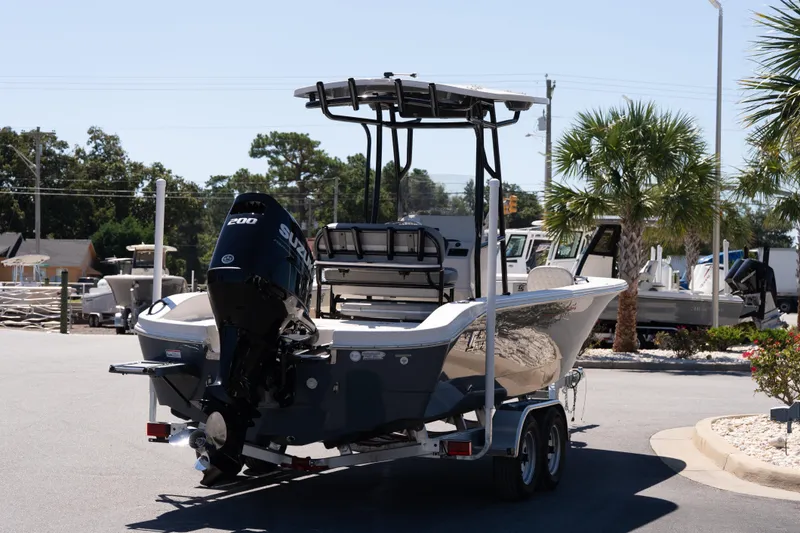Slide: The Image of 2026 Carolina Skiff 22 Ultra Elite boat on trailer, parked outdoors with palm trees. - 6