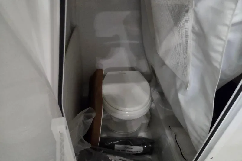 Slide: The Image of 2026 Sea Hunt Ultra 245 SE boat interior with compact marine toilet. - 14