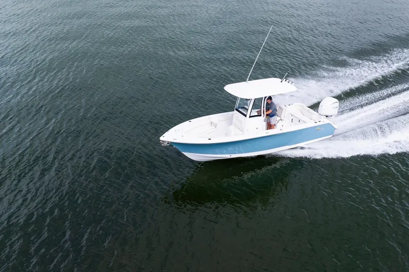 Slide: The Image of 2026 Sea Hunt Ultra 245 SE boat displayed at an indoor exhibition with Yamaha engine. - 2