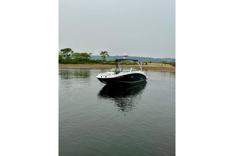 Slide: The Image of 2016 Four Winns Ho270 boat on calm water near a shoreline. - 22