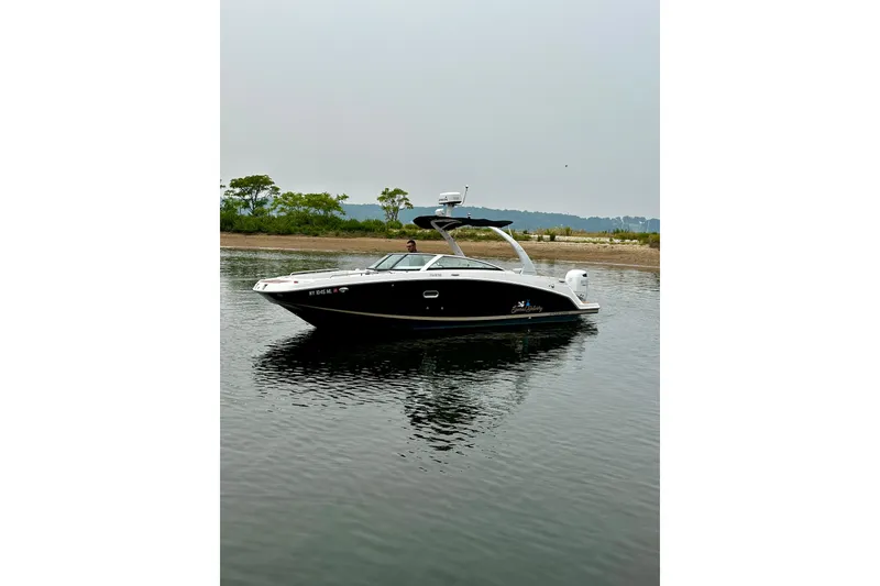 Slide: The Image of 2016 Four Winns Ho270 boat on calm water near a shoreline. - 24