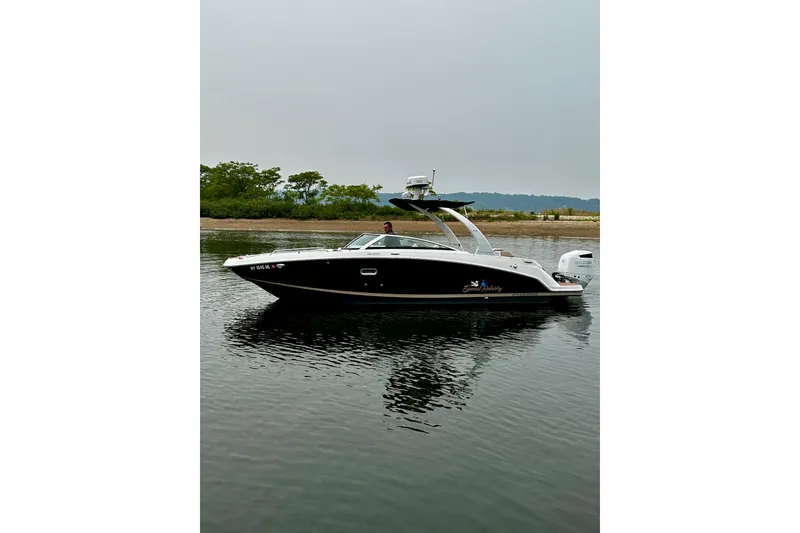 Slide: The Image of 2016 Four Winns Ho270 boat on calm water, with lush greenery in the background. - 26