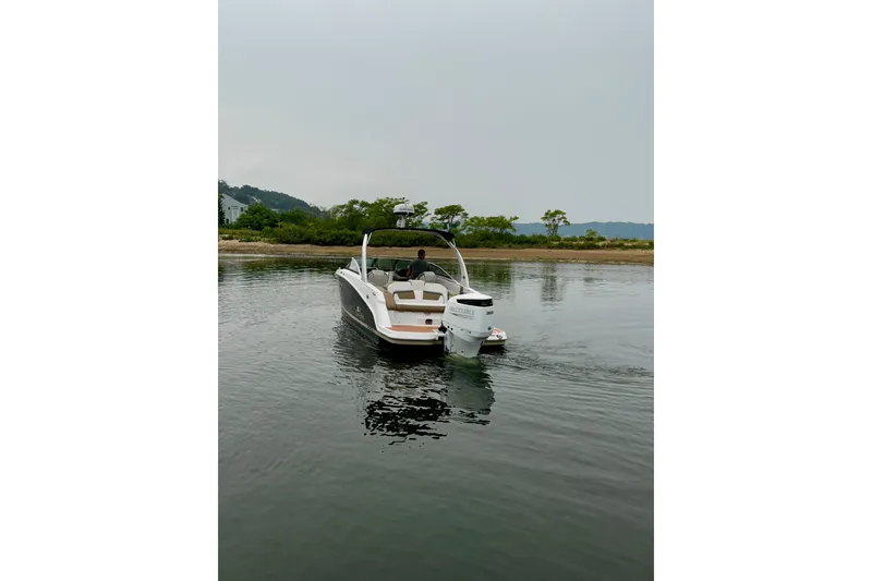 Slide: The Image of 2016 Four Winns Ho270 boat on calm water near a shoreline. - 38