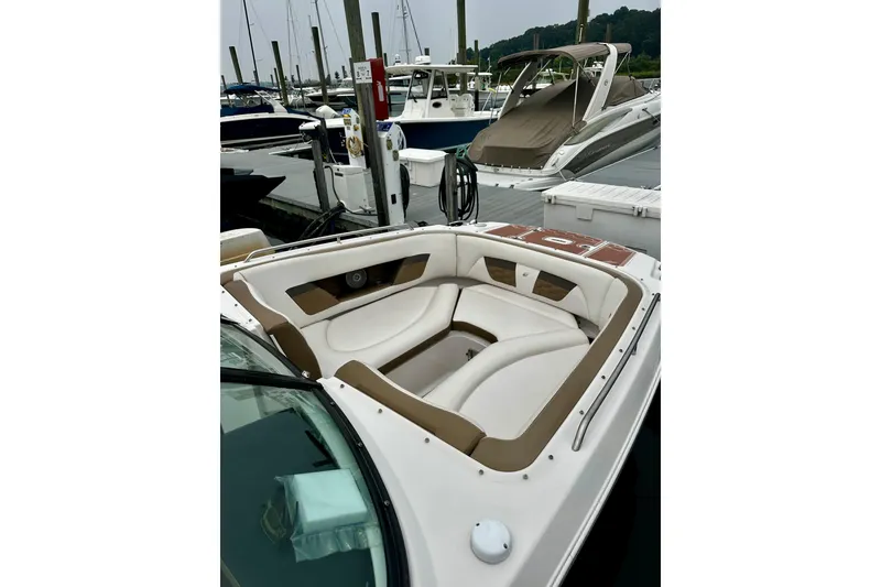 Slide: The Image of 2016 Four Winns Ho270 boat with white and brown seating at a marina dock. - 45