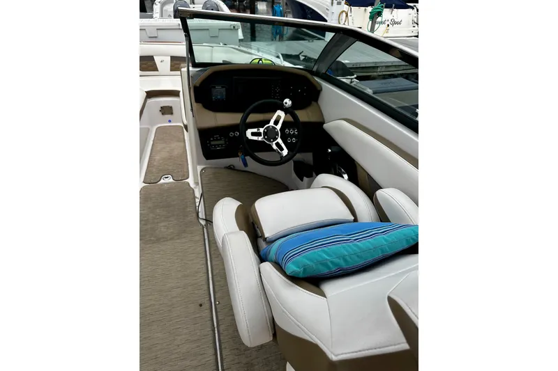 Slide: The Image of 2016 Four Winns Ho270 boat interior with steering wheel and cushioned seating. - 60