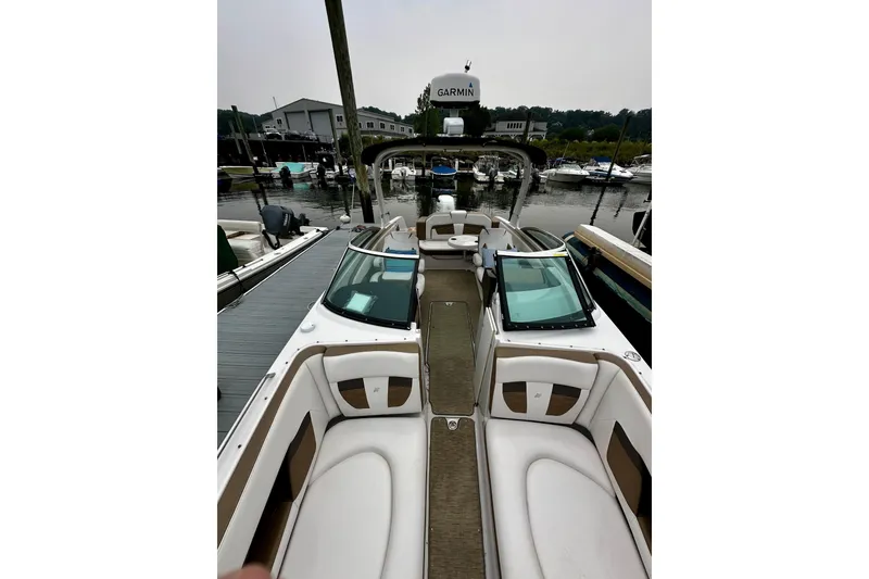 Slide: The Image of 2016 Four Winns Ho270 boat interior at marina, featuring sleek seating and Garmin equipment. - 61