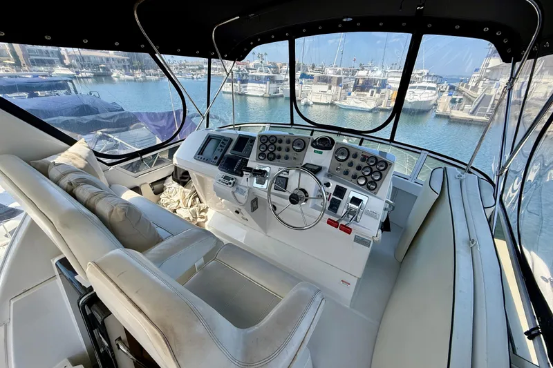 Slide: The Image of Interior view of 2000 Carver 356 Aft Cabin Motor Yacht helm with marina backdrop. - 10