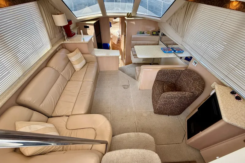 Slide: The Image of Interior of 2000 Carver 356 Aft Cabin Motor Yacht with beige seating and dining area. - 14