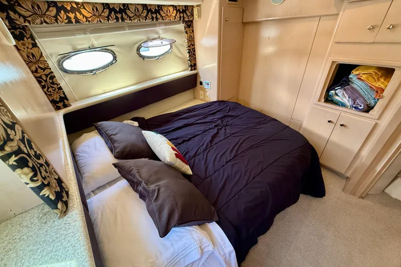 Slide: The Image of Cozy bedroom in 2000 Carver 356 Aft Cabin Motor Yacht with elegant decor and porthole windows. - 27