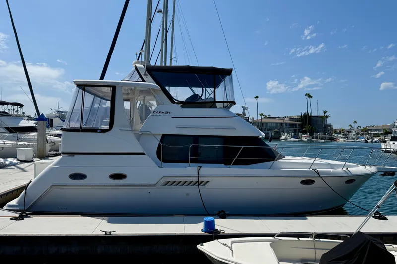 Slide: The Image of 2000 Carver 356 Aft Cabin Motor Yacht docked at marina under clear blue sky. - 6