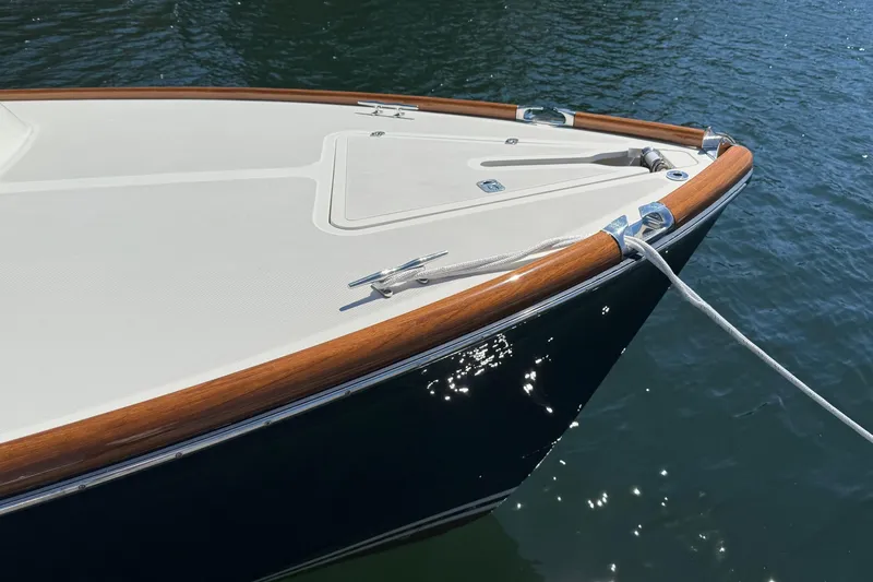 Slide: The Image of 2001 Hinckley Classic Picnic Boat bow with teak accents on calm water. - 11