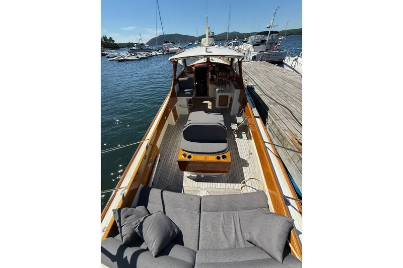 Slide: The Image of 2001 Hinckley Classic Picnic Boat docked, featuring elegant wooden deck and comfortable seating. - 14