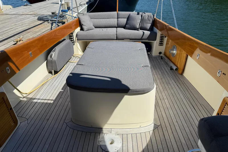 Slide: The Image of 2001 Hinckley Classic Picnic Boat interior with cushioned seating and wooden deck. - 18