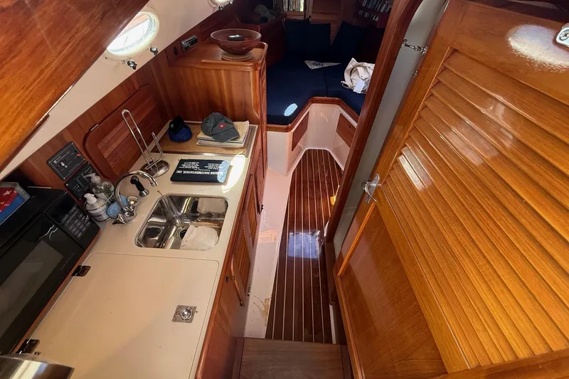 Slide: The Image of 2001 Hinckley Classic Picnic Boat interior with wooden cabinetry and compact kitchen area. - 47