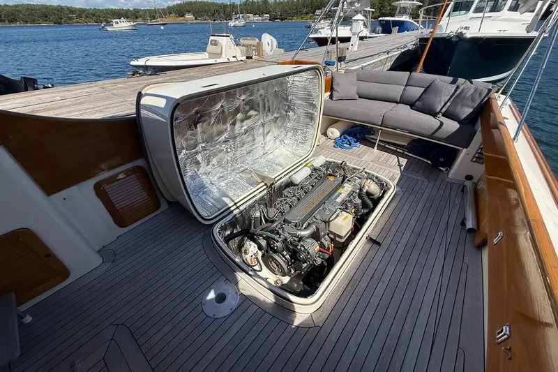 Slide: The Image of 2001 Hinckley Classic Picnic Boat engine compartment open on deck, docked by the water. - 69