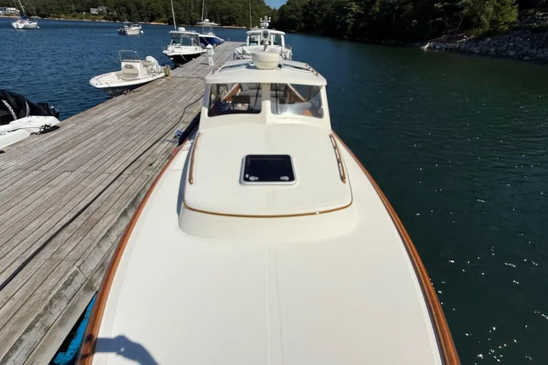 Slide: The Image of 2001 Hinckley Classic Picnic Boat docked on calm water, surrounded by other boats. - 9