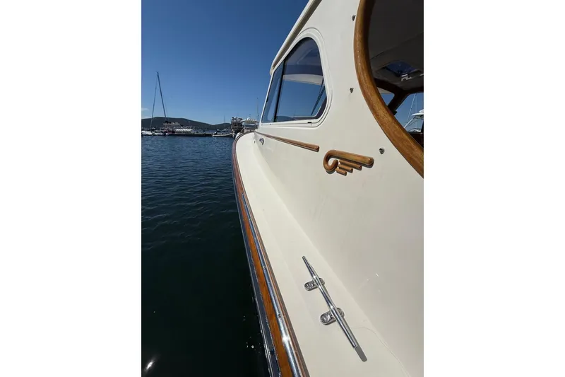 Slide: The Image of 2001 Hinckley Classic Picnic Boat on calm water, showcasing elegant design and craftsmanship. - 12