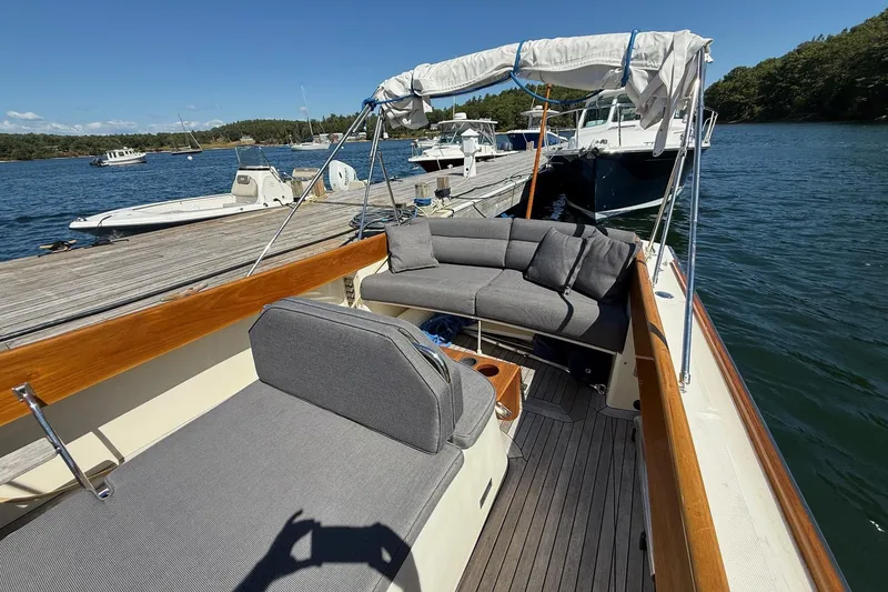 Slide: The Image of 2001 Hinckley Classic Picnic Boat docked, featuring elegant seating and wooden accents. - 16