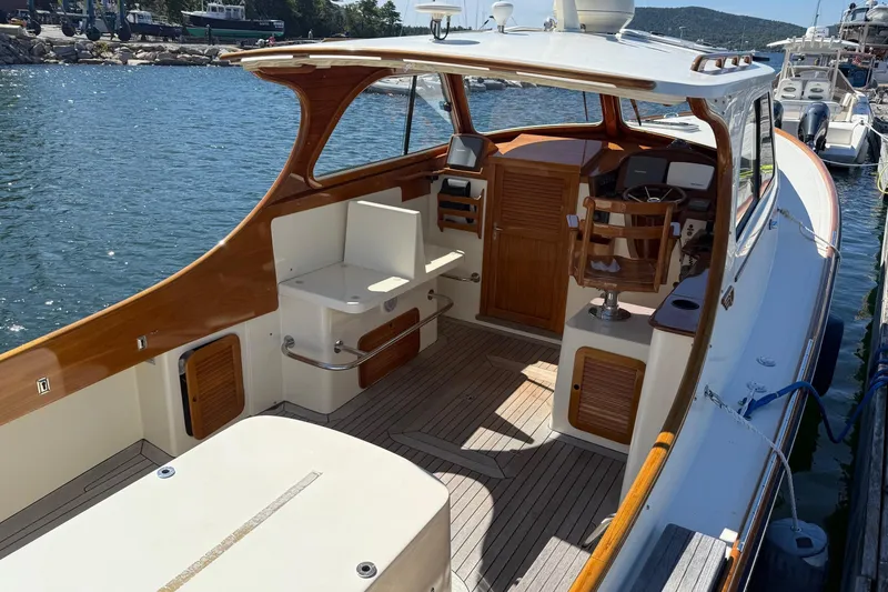 Slide: The Image of 2001 Hinckley Classic Picnic Boat with wooden interior, docked by the water. - 24