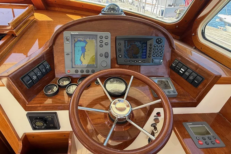 Slide: The Image of Helm of 2001 Hinckley Classic Picnic Boat with navigation instruments and wooden steering wheel. - 30