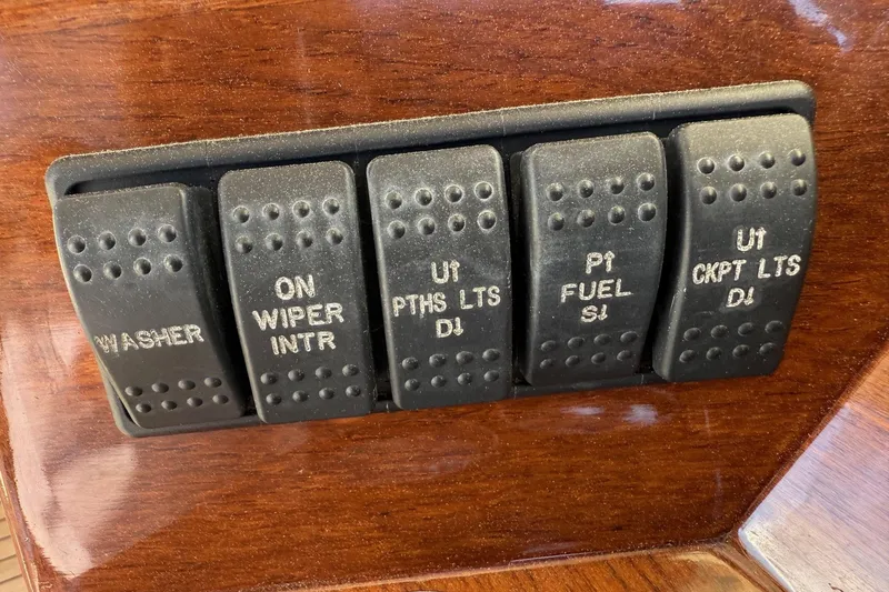 Slide: The Image of Control panel switches on a 2001 Hinckley Classic Picnic Boat dashboard. - 39