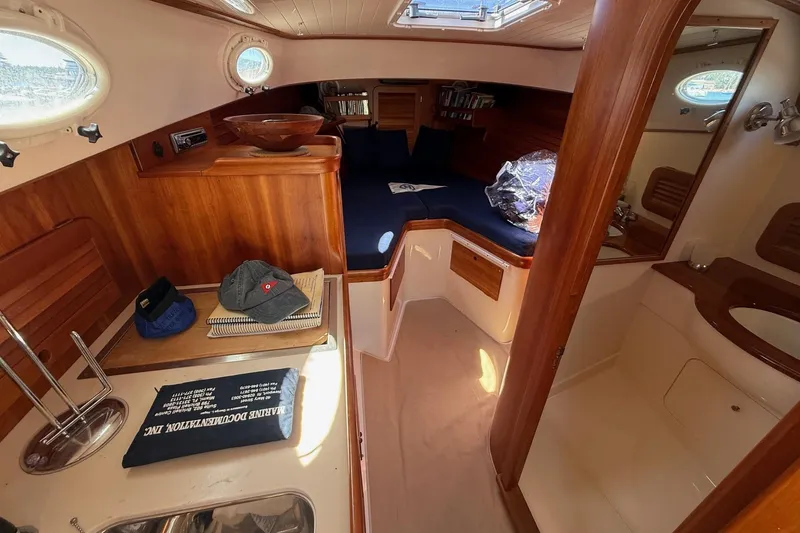 Slide: The Image of 2001 Hinckley Classic Picnic Boat interior with wood finish and cozy seating area. - 48