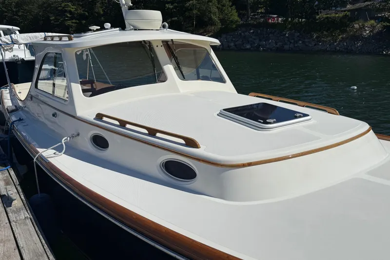 Slide: The Image of 2001 Hinckley Classic Picnic Boat docked on calm water, showcasing elegant design and craftsmanship. - 5