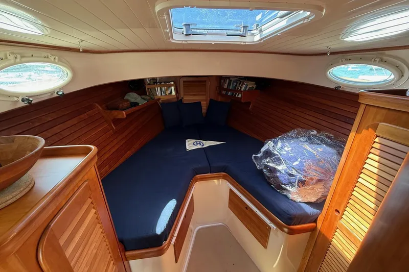 Slide: The Image of Interior of 2001 Hinckley Classic Picnic Boat with cozy wooden cabin and blue cushions. - 52