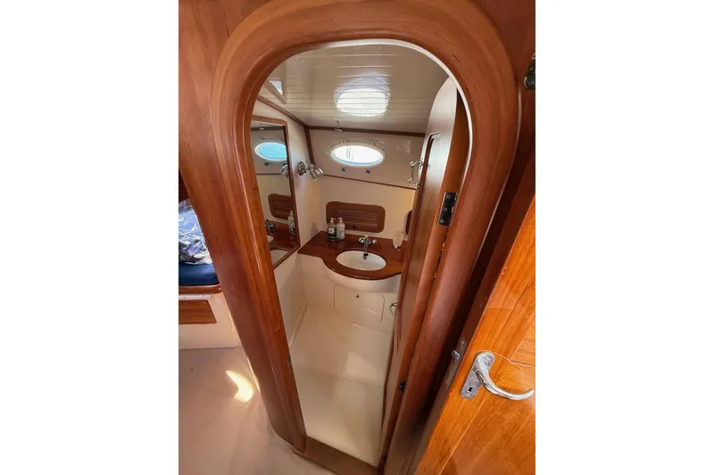 Slide: The Image of Interior of 2001 Hinckley Classic Picnic Boat bathroom with wooden finish and porthole window. - 57
