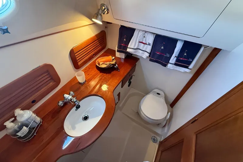 Slide: The Image of Hinckley Classic Picnic Boat 2001 bathroom with wooden countertop, sink, and marine toilet. - 59