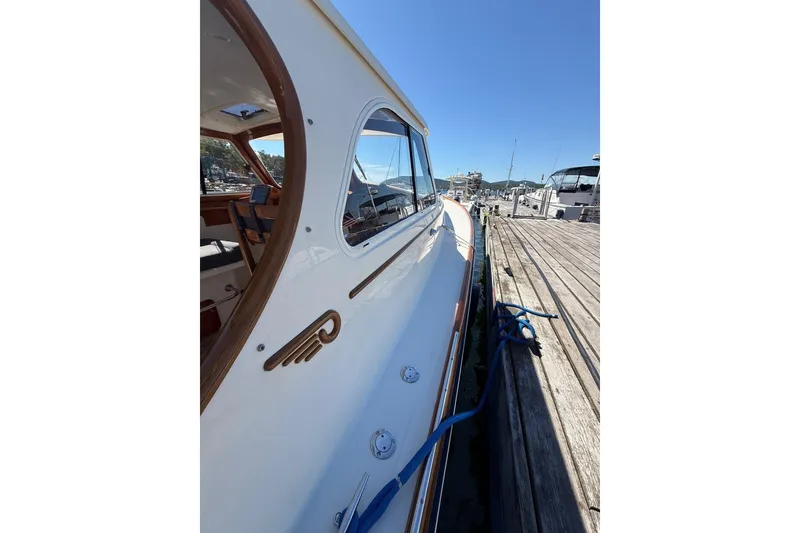 Slide: The Image of 2001 Hinckley Classic Picnic Boat docked at a marina under clear blue skies. - 13