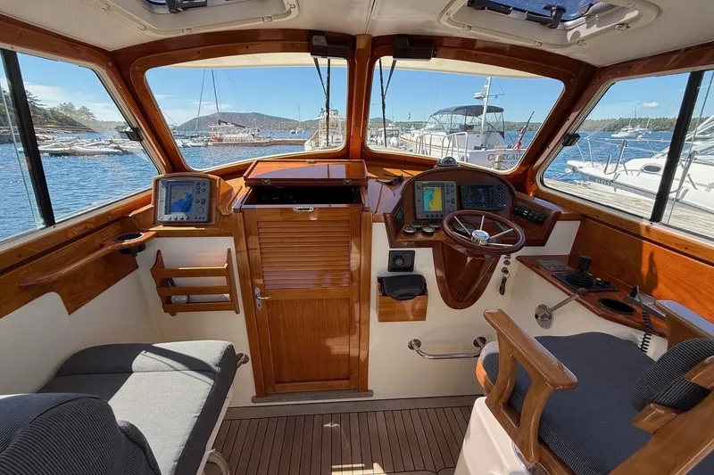 Slide: The Image of 2001 Hinckley Classic Picnic Boat interior with wooden helm and navigation equipment. - 28