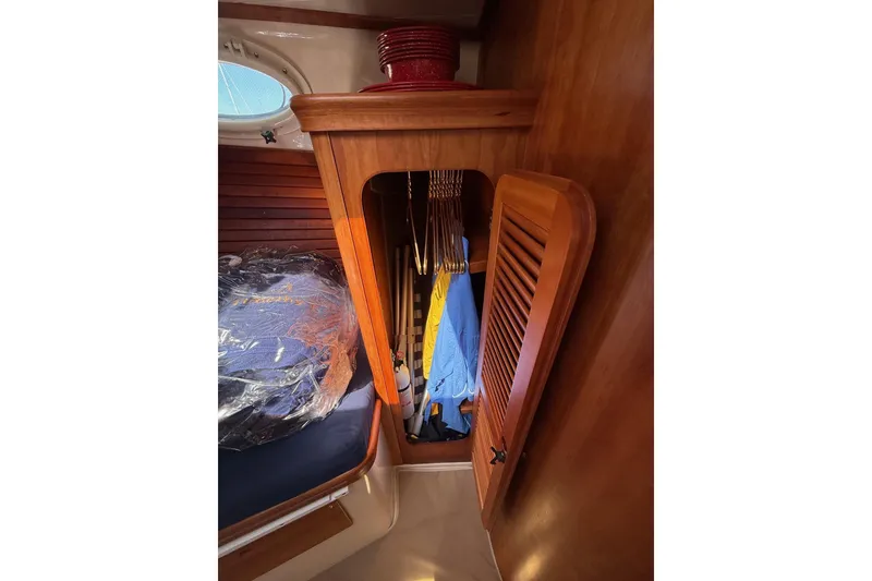 Slide: The Image of 2001 Hinckley Classic Picnic Boat interior with wooden closet and hanging clothes. - 56