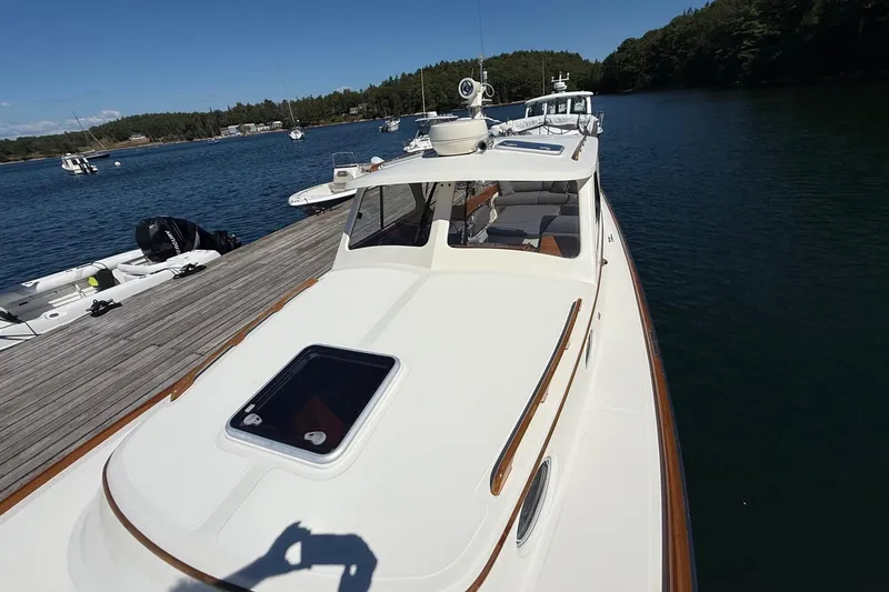 Slide: The Image of 2001 Hinckley Classic Picnic Boat docked on serene waters, showcasing elegant design. - 6