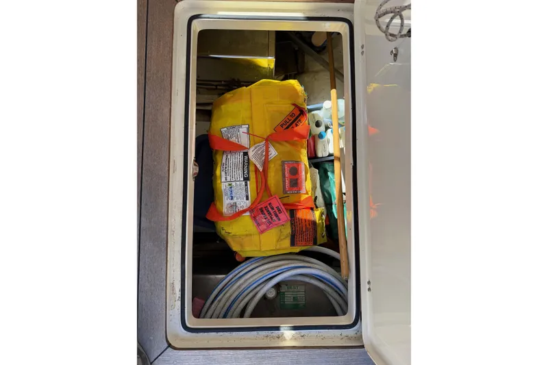 Slide: The Image of Storage compartment on a 2001 Hinckley Classic Picnic Boat with safety equipment and supplies. - 68