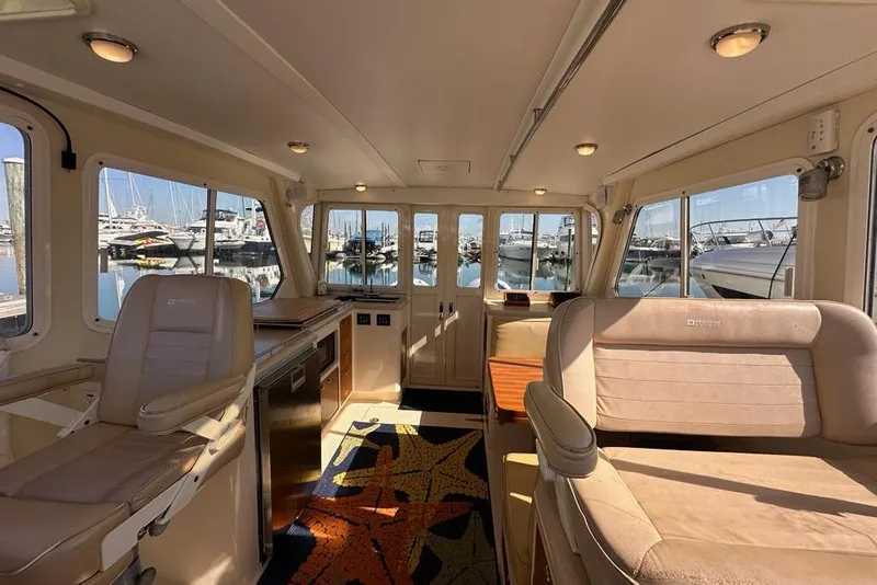 Slide: The Image of Interior of 2002 True North 38 Heritage yacht with plush seating and marina view. - 13