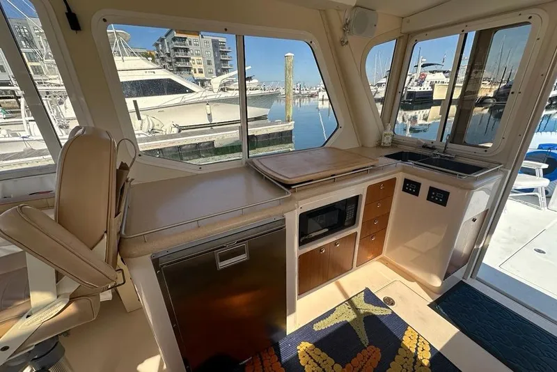 Slide: The Image of Interior of 2002 True North 38 Heritage yacht with kitchenette and marina view. - 15