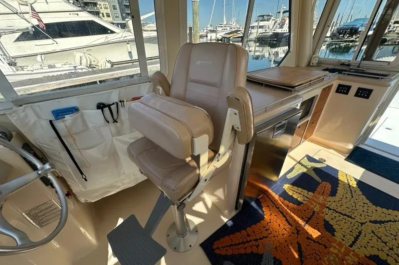 Slide: The Image of Interior of 2002 True North 38 Heritage yacht with helm seat and marina view. - 16