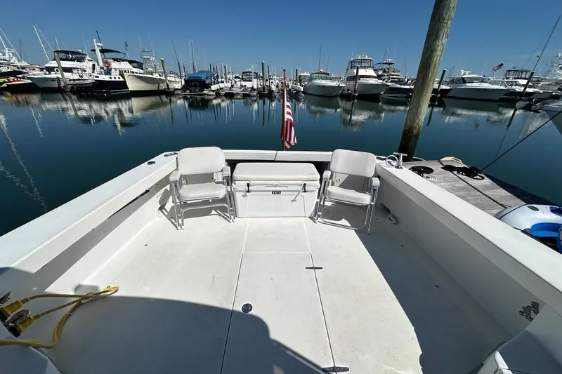 Slide: The Image of 2002 True North 38 Heritage boat docked at marina with chairs and American flag. - 43
