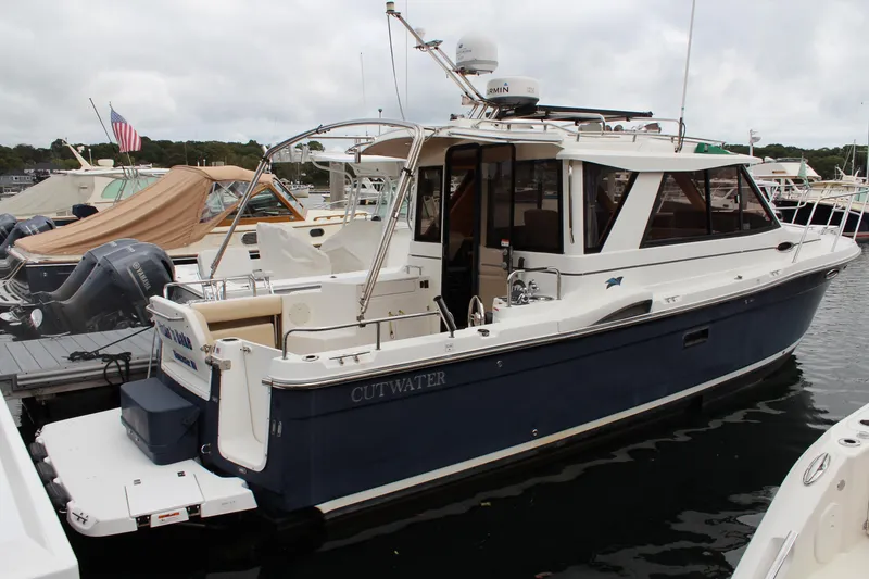 Slide: The Image of 2013 Cutwater 28 LE boat docked at marina, featuring sleek design and modern amenities. - 1