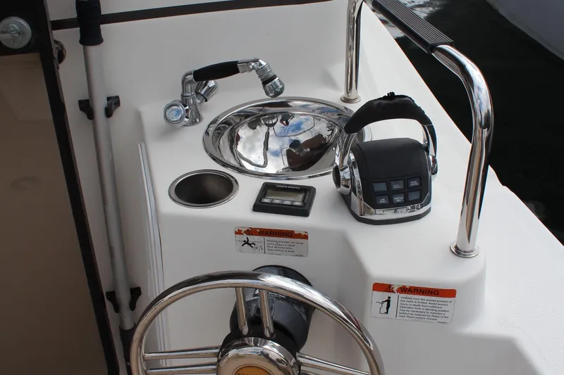 Slide: The Image of 2013 Cutwater 28 LE boat helm with steering wheel, sink, and control panel. - 14