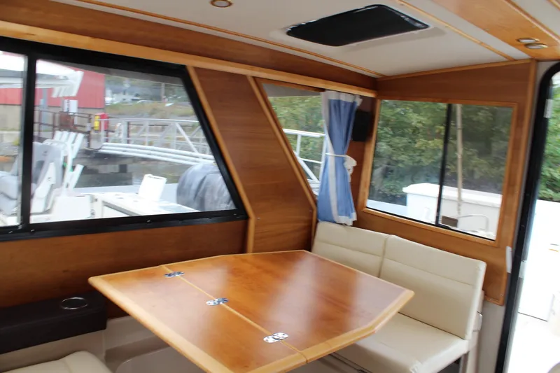 Slide: The Image of Interior of 2013 Cutwater 28 LE boat with wooden table and cushioned seating. - 15