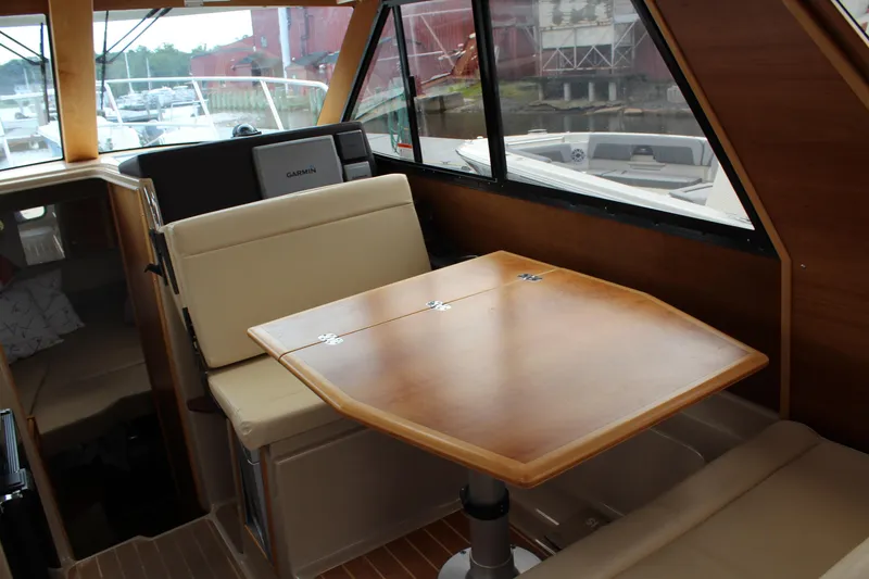 Slide: The Image of Interior of 2013 Cutwater 28 LE boat with wooden table and beige seating. - 17