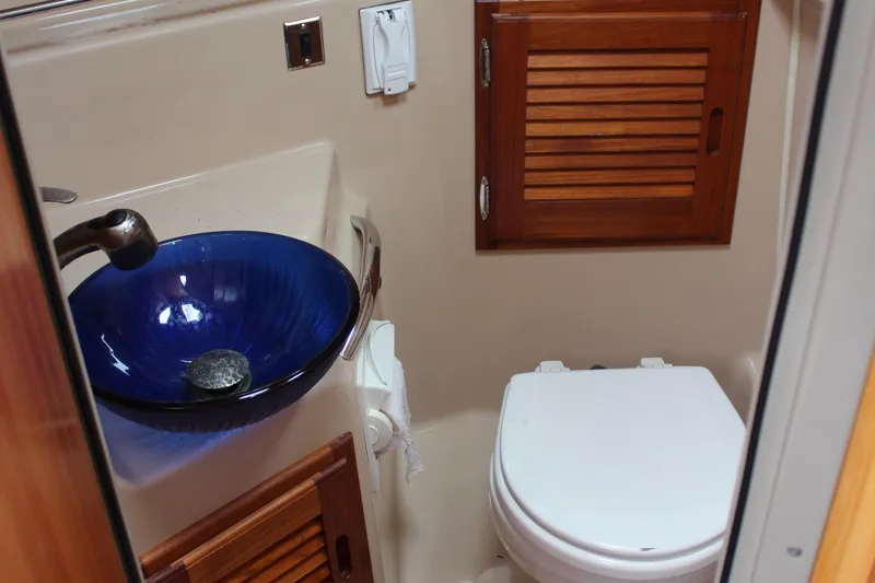 Slide: The Image of 2013 Cutwater 28 LE bathroom with blue glass sink and wooden cabinet. - 19