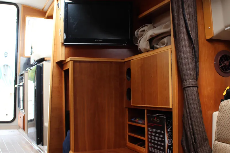 Slide: The Image of Interior of 2013 Cutwater 28 LE with wooden cabinetry and mounted TV. - 20