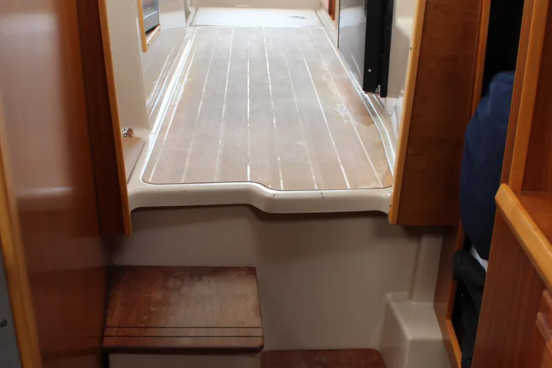 Slide: The Image of Interior view of 2013 Cutwater 28 LE boat with wooden flooring and steps. - 21