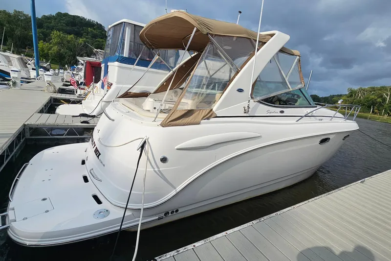 The Image of 2004 Chaparral Signature 310 boat docked at marina under cloudy sky. - 1