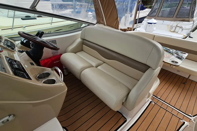 Slide: The Image of 2004 Chaparral Signature 310 boat interior with beige seating and wooden flooring. - 12