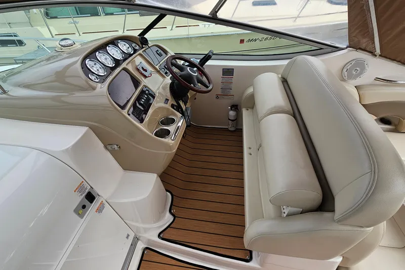 Slide: The Image of 2004 Chaparral Signature 310 boat interior with steering wheel and beige seating. - 13