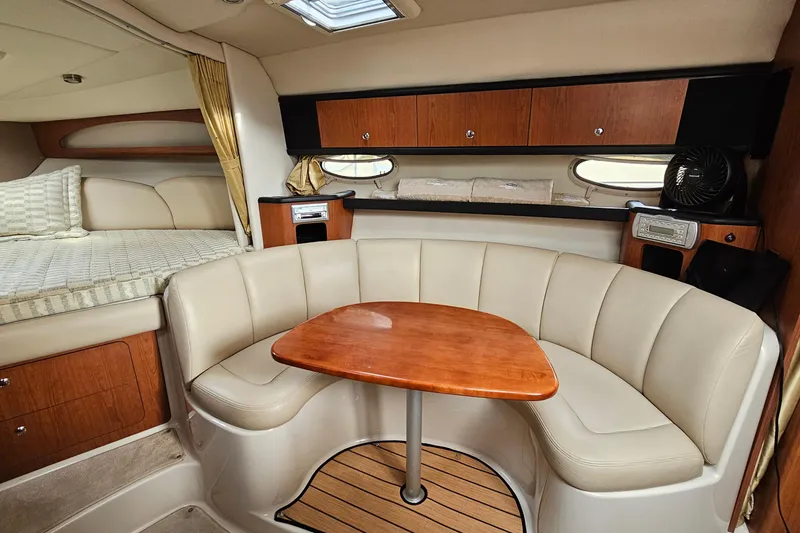 Slide: The Image of 2004 Chaparral Signature 310 interior with cozy seating, wooden table, and elegant cabinetry. - 18